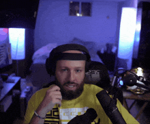 a man with a beard wearing headphones and a yellow shirt with the number 235 on it