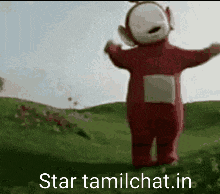 a red teletubbies character is standing in a grassy field with his arms outstretched .