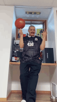 a man in a mexico 420 jersey holds a basketball in his hands