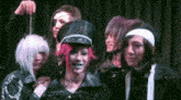 a group of people are posing for a picture on a stage in front of a curtain .