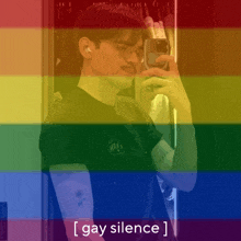 a man taking a selfie in front of a rainbow flag with the words gay silence