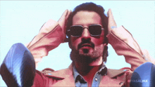 a man wearing sunglasses and a pink jacket with the name miyasaliha on the bottom right