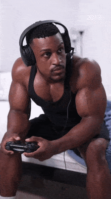 a muscular man wearing headphones is playing a video game in 2018
