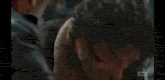 two men are standing next to each other and one of them is holding another man 's face .