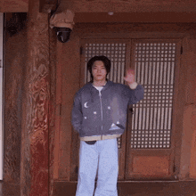 a man in a purple jacket stands in front of a wooden door