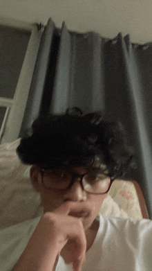 a young man wearing glasses and a white shirt