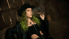 a woman with green hair smoking a cigar