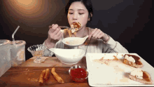 a woman is sitting at a table eating a meal