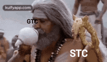 a man with long hair and a beard is drinking from a white cup .