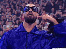 a man with a beard wearing sunglasses and a blue coat