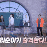 a group of people standing in front of a blackboard that says blackpink school