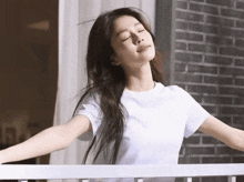 a woman in a white shirt with her eyes closed