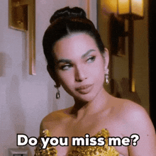 a woman in a gold dress is asking if she misses me