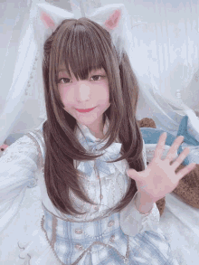 a girl wearing a cat ear headband and a blue dress