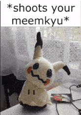 a stuffed animal is sitting on a table with a caption that says " shoots your meemyu "