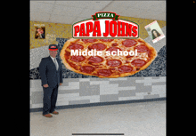 a man standing in front of a pizza that says papa johns