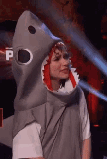 a woman is wearing a shark costume with a shark head .