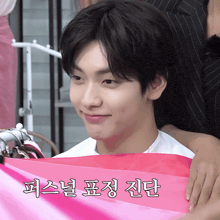a person holding a pink piece of cloth with korean writing on it