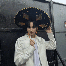a man wearing a sombrero is standing in front of a door