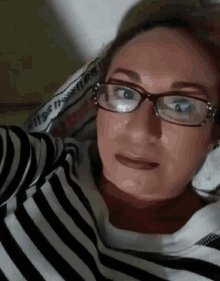 a woman wearing glasses and a striped shirt