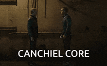 two men are standing next to each other in a dark room with the words canchiel core below them