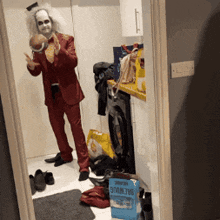 a man in a red suit is standing in a laundry room next to a box of salt