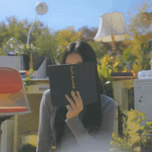 a woman covers her face with a book titled rich randall