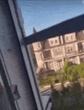a blurry picture of a house from a window with a blue sky in the background