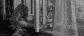 a woman is sitting on a window sill looking out a window .