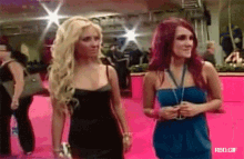 two women are standing next to each other on a pink carpet with rbd.gif written on the bottom