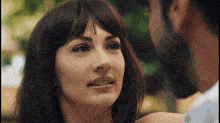 a man and a woman are looking at each other and smiling