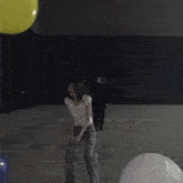 a woman in a white shirt is standing in front of a yellow ball