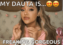 a woman in a pink shirt is holding a cup and says " my dauta is freaking gorgeous "