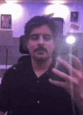 a man with a mustache is taking a selfie in front of a mirror