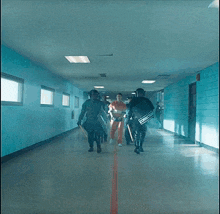 a group of men are walking down a hallway with a corrections sign on their back