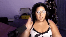a woman wearing headphones and glasses talking into a microphone