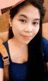 a woman wearing a pink hat and a blue shirt with a brown strap