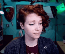 a woman with red hair is wearing a black sweater