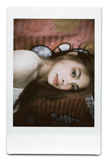 a photo of a woman laying on a bed with a hello kitty blanket