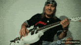 a man playing a guitar with a bandana on his head