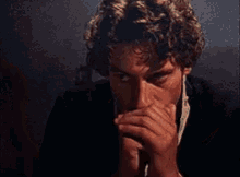 two men are looking at each other in a dark room and one of them has a tooth missing .