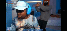 a man wearing headphones and a hat is sitting in front of a screen that says bbg subs 2,059 / 2,500