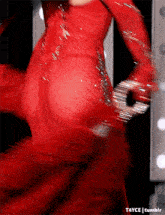 a woman in a red dress is dancing in a blurry photo .