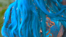 a close up of a woman 's face with blue hair and a black shirt .