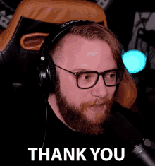 a man wearing headphones and glasses says " thank you "