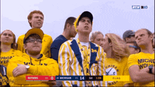 a group of people are watching a michigan game