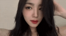a close up of a woman 's face with long black hair .