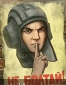 a man wearing a helmet is holding his finger to his mouth
