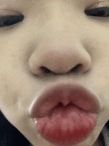 a close up of a woman 's face with her eyes closed and red lips