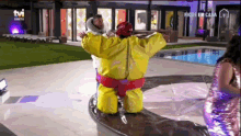 a man in a yellow sumo suit is being held by another man